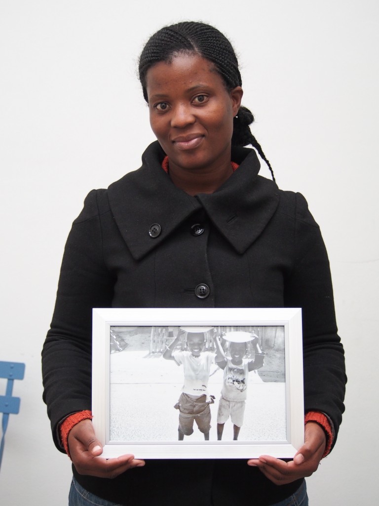 Nwabisa Ndongeni, mother of 2 holds a 12"x8" print of her 1.0 series postcard